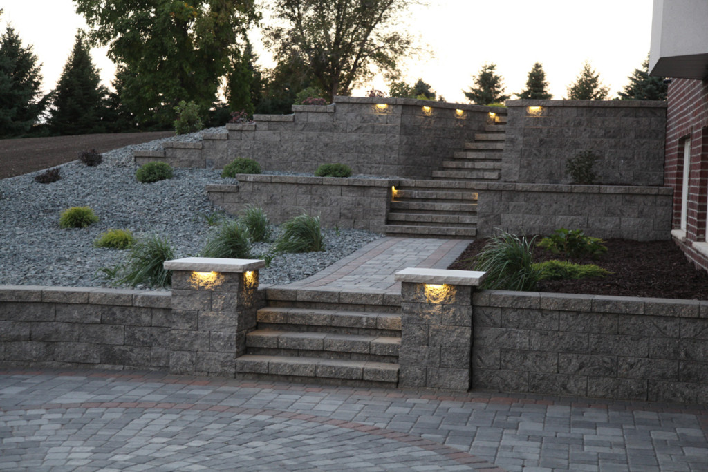Paver patio with retaining walls & steps and landscape beds surrounding and landscape lighting