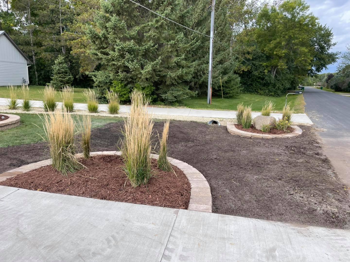 Front yard landscaping with ornamental grass, mulch & retaining walls